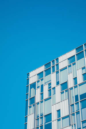 Edifício moderno de vidro contra céu azul claro — Edifício Papéis de Parede