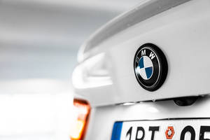 Primer plano del emblema trasero de un coche BMW blanco con gotas de lluvia. — Logo Fondos de pantalla