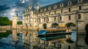 Bateau touristique passe sous un château historique avec un reflet parfait dans l'eau. — Bâtiment Fonds d'écran