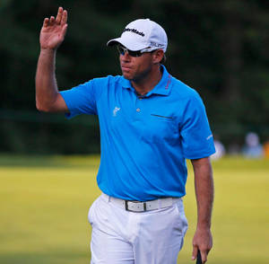 Professionell golfspelare vinkar till publiken på grön bana — Wave Bakgrundsbilder