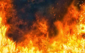 Fiamme vibranti avvolgono l'inquadratura con braci incandescenti e fumo scuro. — Fuoco Sfondi