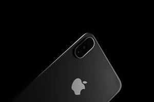 Close-up of a black iPhone with silver logo and dual camera against black background. — iPhone Xs Wallpaper