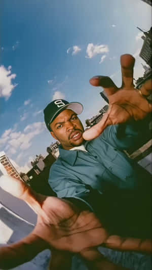 Man in cap with hands outstretched looking at camera against city sky — Cool Rap Wallpaper