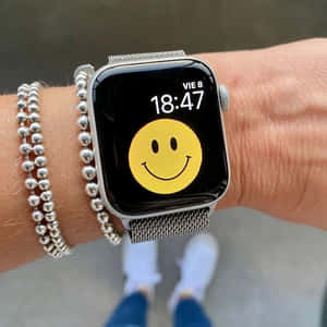 Håndled med Apple Watch, der viser smiley og sølv perlearmbånd. — Apple Watch Wallpapers