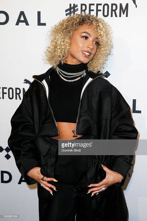 Mulher de roupa preta com cabelo loiro cacheado em um evento com marca. — Moda Papéis de Parede