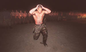 Soldado frotándose la cabeza durante entrenamiento militar nocturno con otros en formación. — Militar Fondos de pantalla