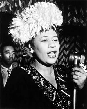 Una cantante de jazz actúa con sombrero de plumas y vestido de cuentas en un club nocturno de los años 40. — Ella Fondos de pantalla