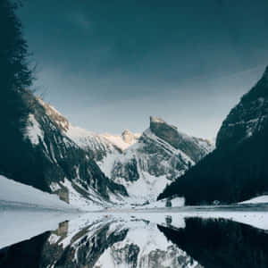 Snowy mountains reflected in a frozen lake under a twilight sky — iPad Air 13 Wallpaper