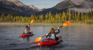 Deux personnes faisant du kayak sur un lac de montagne serein au lever du soleil. — Kayak Fonds d'écran