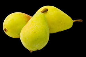 Three ripe yellow pears with red blushes on a black background. — Fruit Wallpaper