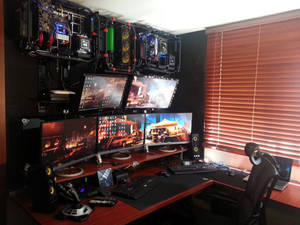 Gaming-Schreibtisch mit mehreren Monitoren und freiliegenden Computerkomponenten an der Wand montiert. — Desktop computer Wallpaper