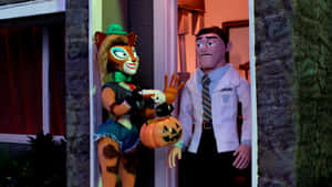 Cartoon cat in witch costume handing pumpkin to dentist at Halloween door. — Hero Wallpaper