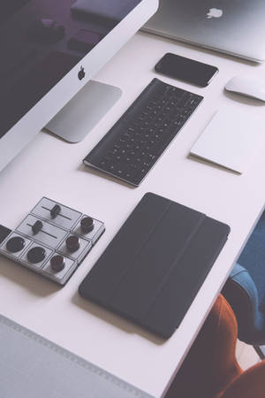 Moderne minimalistisk tech-arbeidsplass med Apple-enheter på et hvitt skrivebord. — iPad Mini Bakgrunner