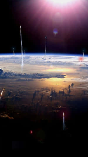Rocket trails streak across Earth's atmosphere during a stunning sunrise from space. — iPhone 8 Plus Wallpaper