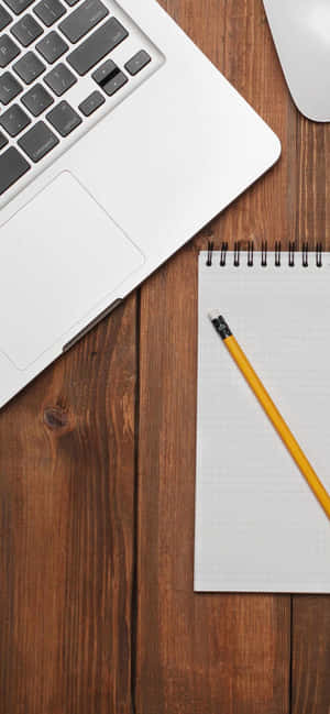 Silver laptop yellow pencil and notebook on wooden desk for work or study — Honor Magic Wallpaper