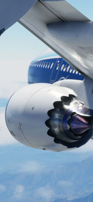 A commercial airplane engine and wing flying over clouds and mountains. — Honor Magic Wallpaper