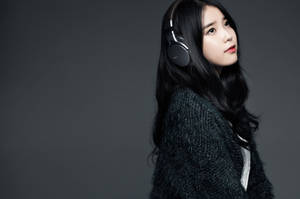 Junge Frau mit Kopfhörern und dunklem Pullover in einem Studio. — Iu Wallpaper