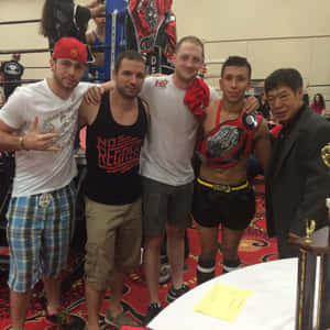 Five men celebrating in a boxing ring with a championship belt. — Gym Wallpaper
