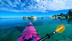 Kayak rose pagayant sur une eau turquoise claire vers des îles rocheuses sous un ciel bleu. — Kayak Fonds d'écran