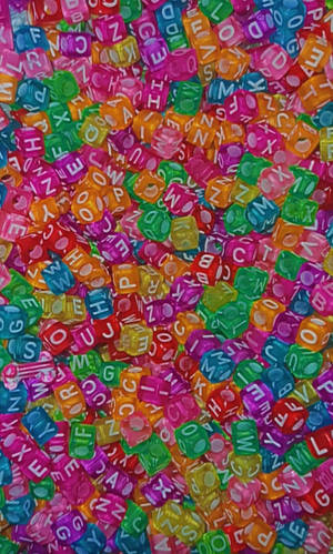 A pile of colorful translucent letter dice with random letters visible. — Kidcore Wallpaper