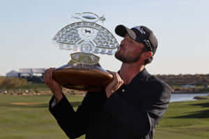 Golfer kissing championship trophy on golf course — Winner Wallpaper