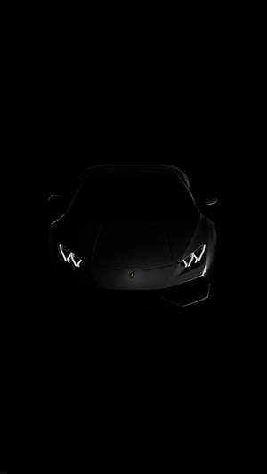 Black Lamborghini sports car with glowing headlights in darkness. — Lamborghini Wallpaper