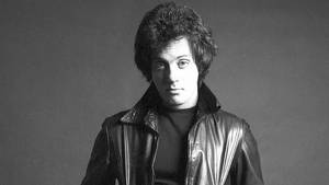 Man in leather jacket looking at camera in studio portrait — Music Wallpaper