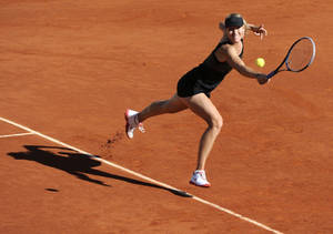 Tennista colpisce una pallina su campo in terra rossa — Francese aperto Sfondi