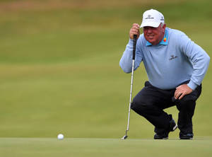 Golfer smiler, mens han sidder på hug for at putte på green. — Golfbane Wallpapers