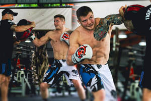 Boxer with tattoos throwing a punch during sparring session in gym. — Gym Wallpaper
