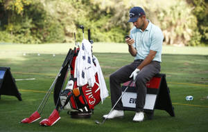 Golfspiller sitter på golfbag og sjekker telefon på solrik bane — Mobile Bakgrunner