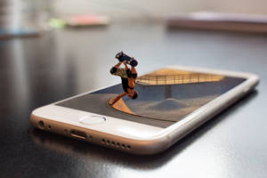 Miniatyr skateboarder utfører et triks over en smarttelefonskjerm som viser en rampe. — Mobile Bakgrunner