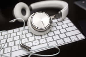 Auriculares blancos over-ear sobre un teclado blanco. — Multimedia Fondos de pantalla