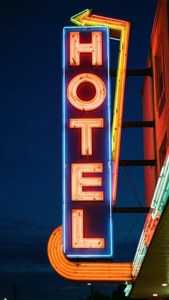A glowing neon hotel sign at night with orange and blue lights. — Hotel Wallpaper