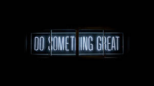 Ein helles Neonschild mit der Botschaft 'Do Something Great' in einem dunklen Raum. — Computer Wallpaper
