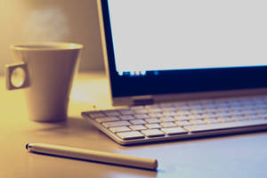 Kaffeetasse Laptop und Stylus auf einem Holztisch in warmem Morgenlicht — Desktop computer Wallpaper
