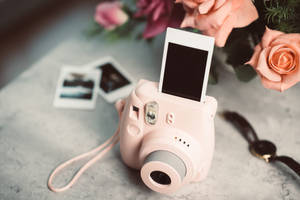 Roze instantcamera met fotostrook en rozen op marmeren oppervlak — Camera Achtergronden