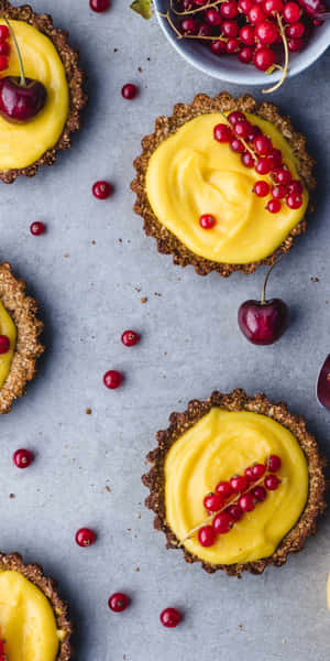 Crostatine al limone guarnite con ribes rosso e ciliegie su una superficie grigia. — Cupcake Sfondi