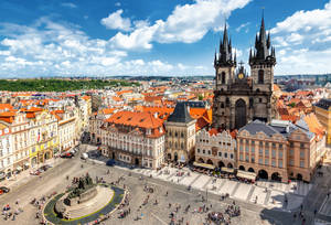 Praça da Cidade Velha de Praga movimentada com pessoas perto da Igreja de Nossa Senhora antes de Týn sob um céu ensolarado. — Edifício Papéis de Parede