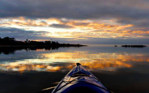 Kayak sur eau calme au coucher du soleil avec reflet coloré du ciel — Kayak Fonds d'écran