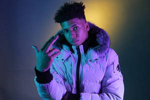 Ung mand i puffy jakke laver håndbevægelse under neonlys. — Ed Wallpapers