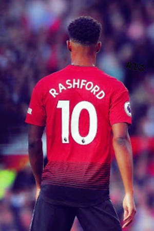Pemain sepak bola mengenakan jersey merah bertuliskan nama Rashford dan nomor 10 menghadap menjauh dari kamera. — Android Wallpaper