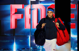 Roger Federer tiene borse da tennis su un palco illuminato con il suo nome visualizzato dietro di lui. — Federer Sfondi