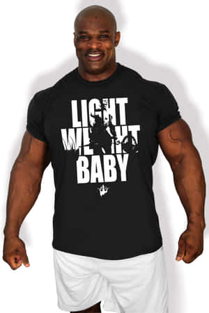 A smiling muscular man wearing a black t-shirt with white text and graphic. — Legend Wallpaper