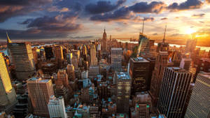 Horizonte de la ciudad de Nueva York al atardecer con luz dorada en rascacielos y nubes dramáticas. — HD Fondos de pantalla