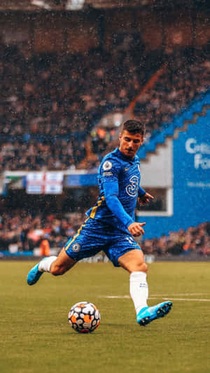 Soccer player dribbling ball in rain during night match at stadium. — Local Wallpaper