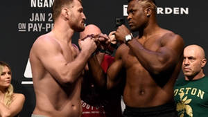 Two MMA fighters lock hands during a pre-fight weigh-in event. — Showdown Wallpaper