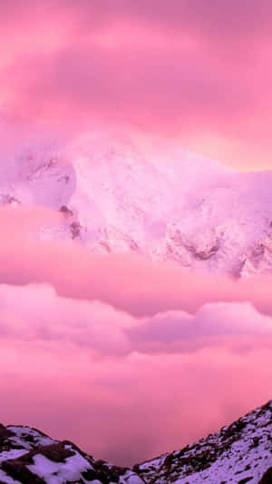 Pink-hued mountain range rising above clouds at twilight. — iPhone 8 Wallpaper