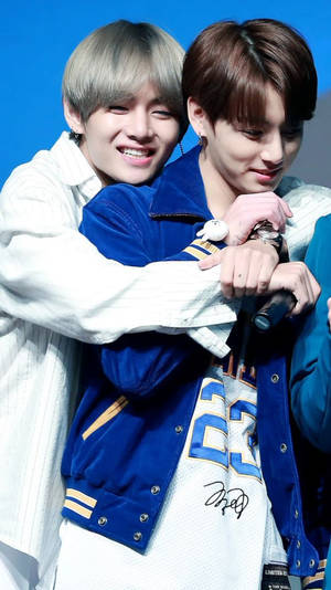 Two K-pop idols hug and smile during a stage performance. — Bts Wallpaper