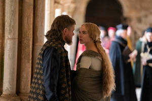 Two people in medieval clothing face each other in a stone hallway. — Duel Wallpaper